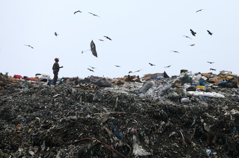 An umbrella flies out of a man's hand due to strong winds at a dumping ground on the outskirts of Mumbai, India, on World Environment Day, June 5, 2020. REUTERS/Francis Mascarenhas    